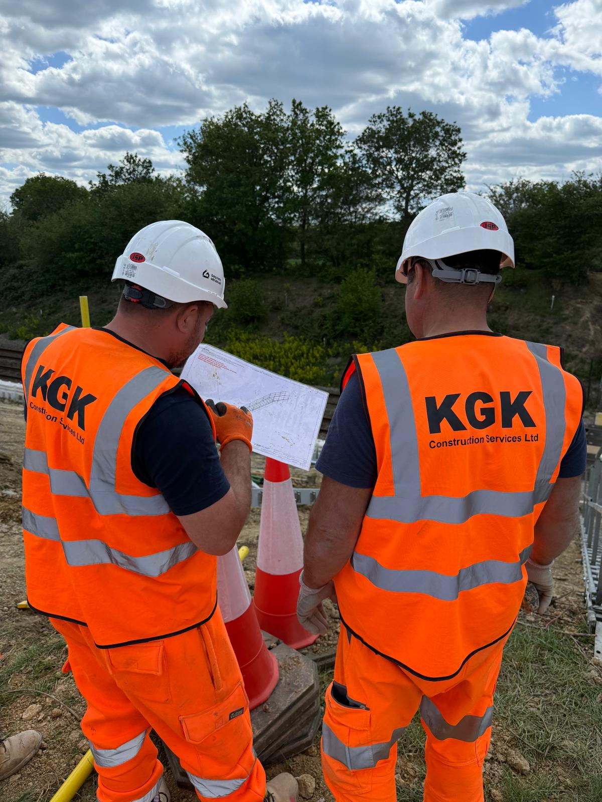 KGK operatives reviewing plans on a rail project site