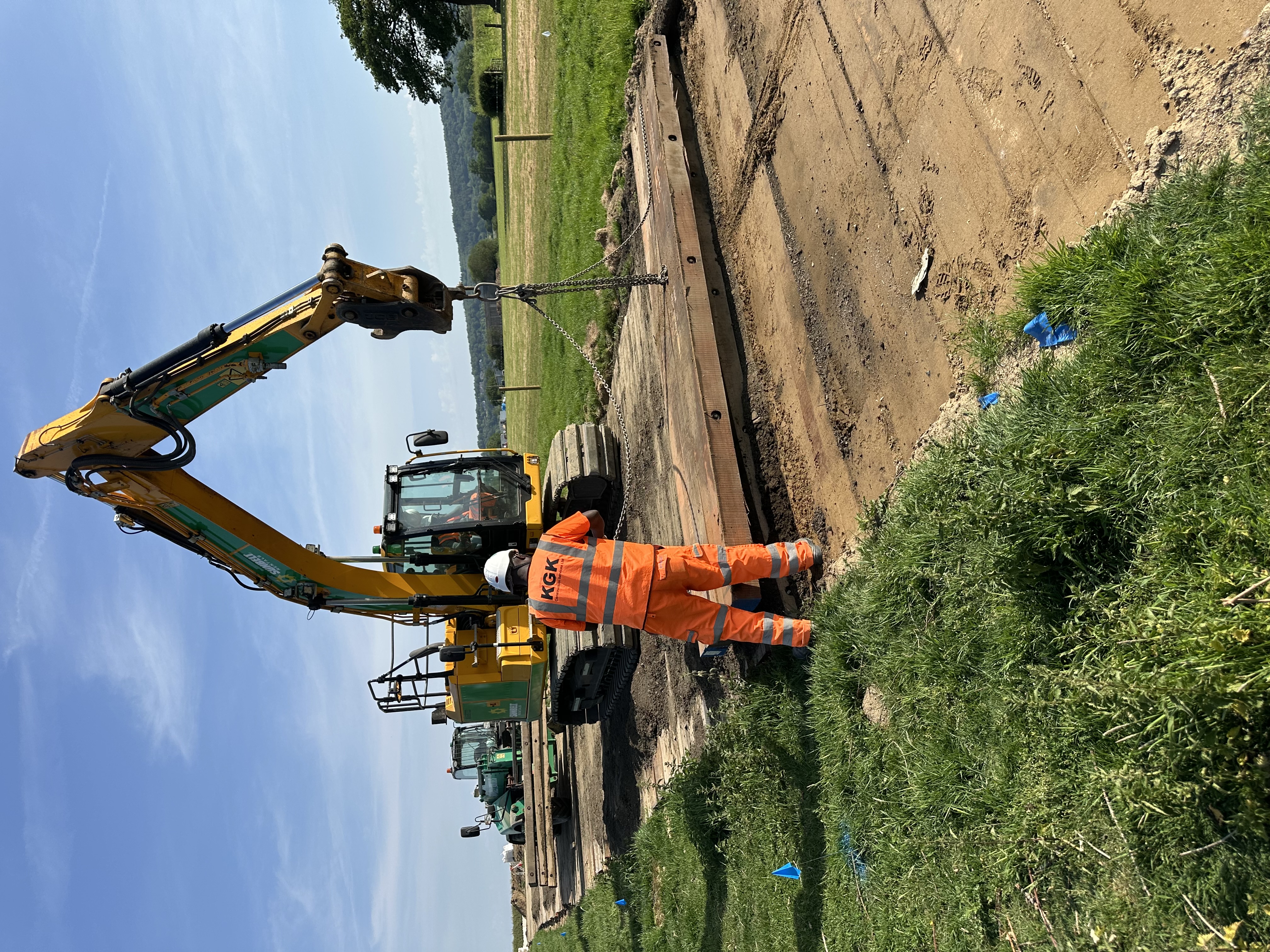 KGK operative directing excavator on groundworks
