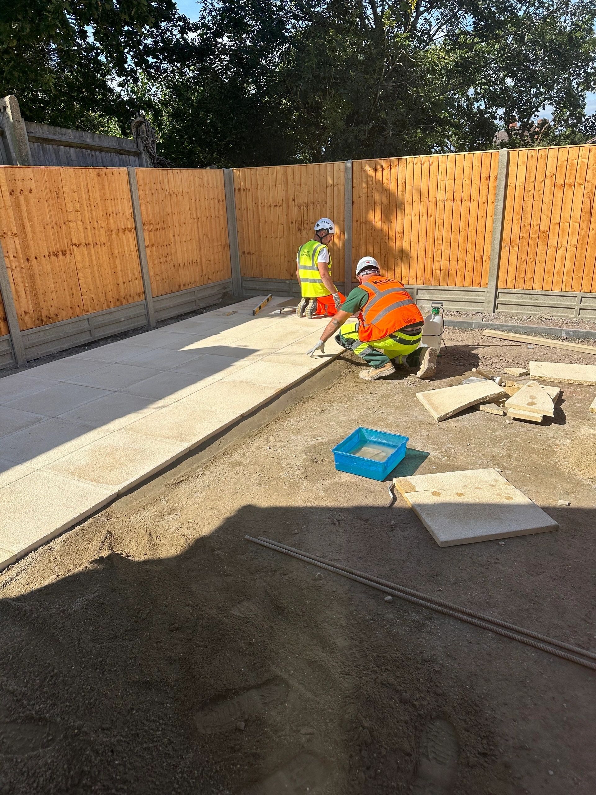 KGK workers laying paving stones